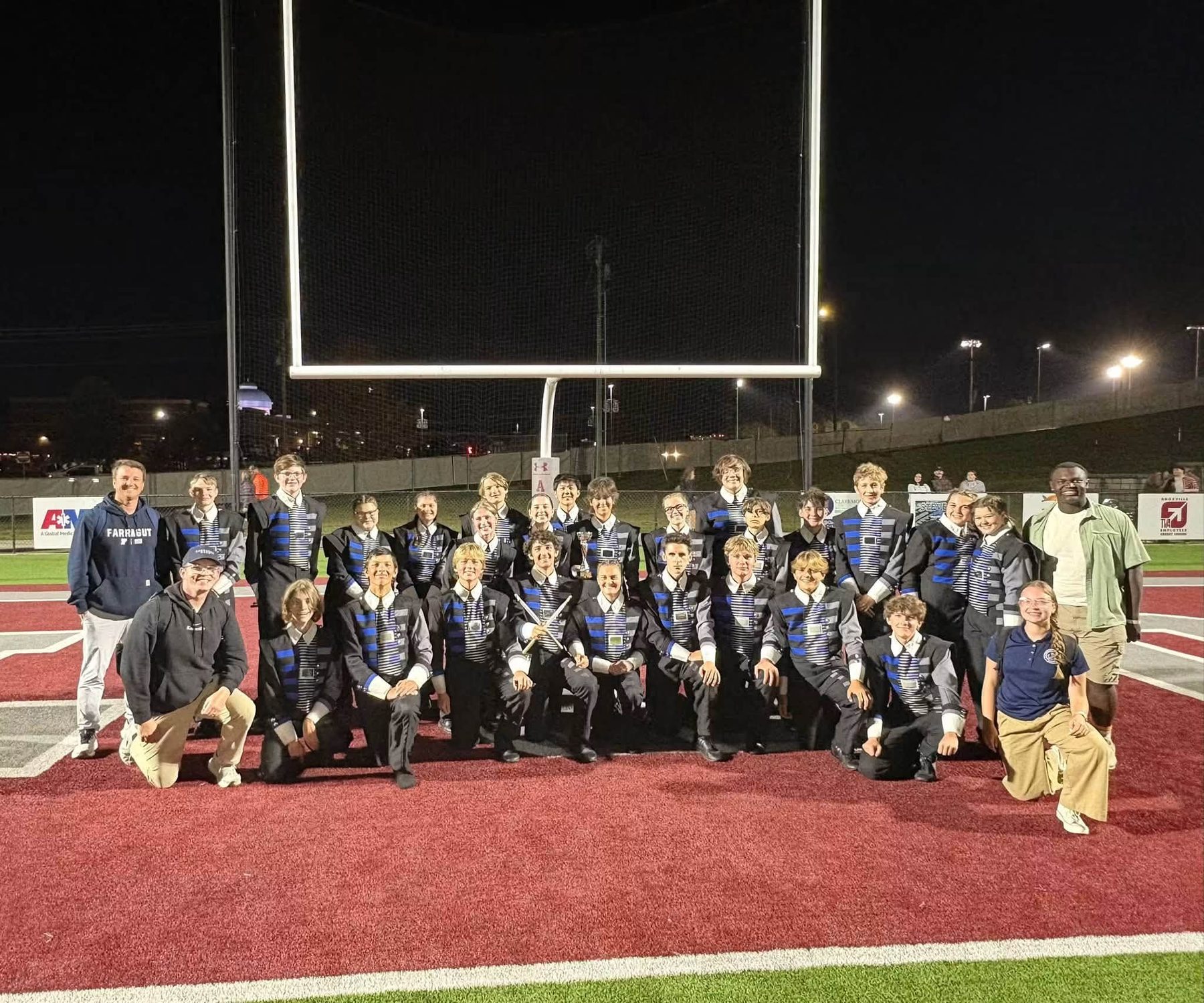 Farragut drumline and staff posing in the end zone after a Friday night game
